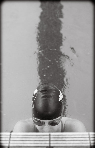 Photograph taken from above looking at swimmer coming out of a pool