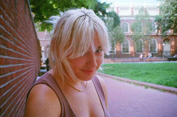 Photograph of person against wall looking into the camera