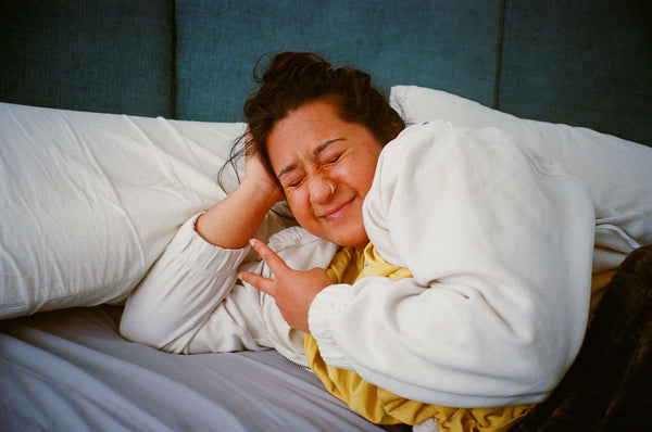 Photograph of person lying on a bed smiling