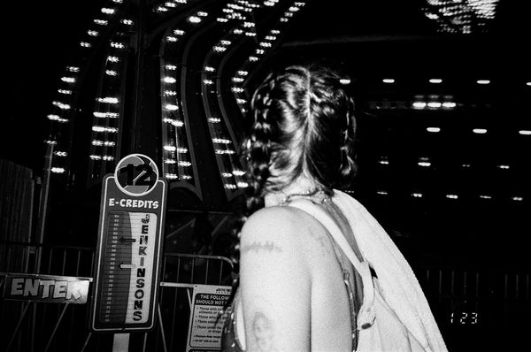 Photograph of person from behind at night at a fair