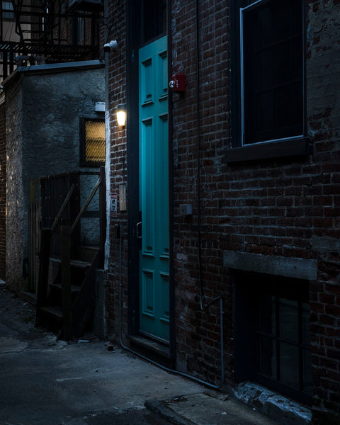 Photograph of blue back door in an alley