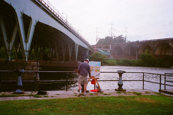 Photograph of person painting by the Schuylkill River in Philadelphia