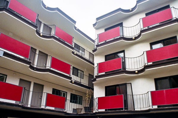 Photograph of apartment complex with red railing balconies
