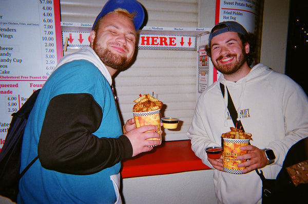 Photograph of two people holding food and smiling