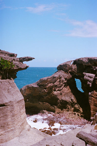 Photograph taken with a Pentax ME camera of beach surrounded by rocks