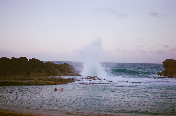 Photograph taken with a Pentax ME camera of ocean wave crashing against a rock