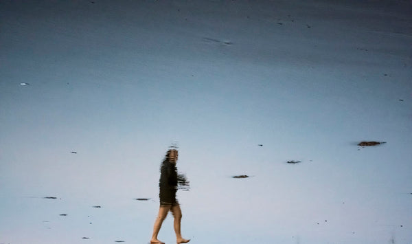 photograph of girl walking on beach
