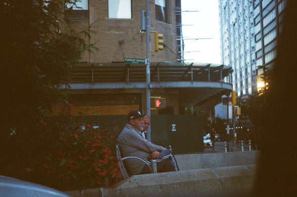 Photograph of two men sitting on a bench in New York City