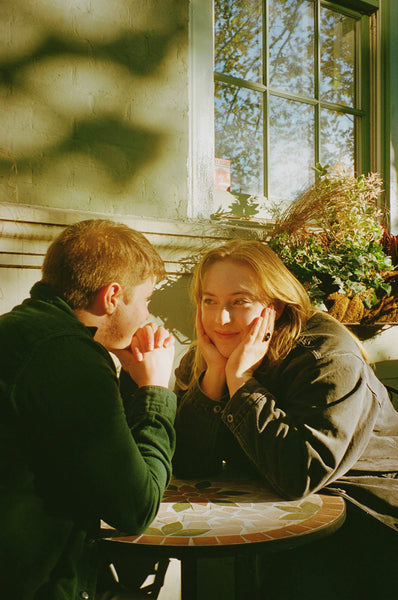 Photograph of a couple sitting at a table outside