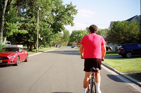 Photograph of person biking down a street