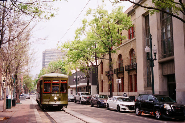 Photograph of old trolley going down a city street
