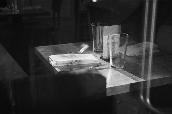 Photograph of a table setting through a street window