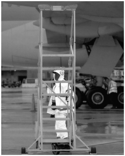 Photograph of person pulling ladder on airport tarmac