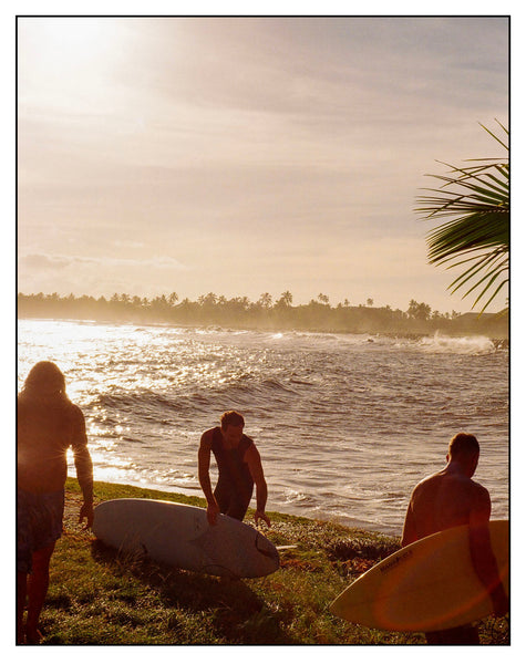 Photograph of surfers on a beach