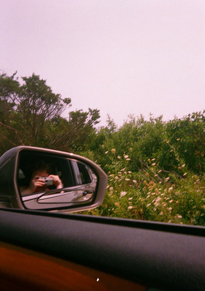 Photograph of someone taking a picture from a car side view mirror