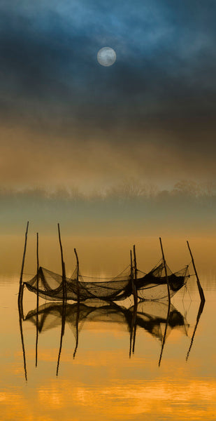 Photograph of lake with black netting at sunset 