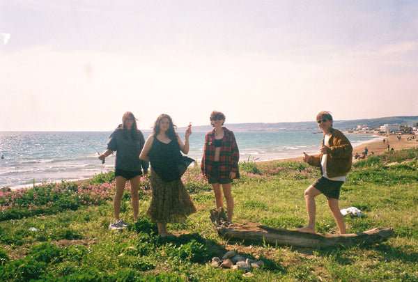 Photograph of group of friends standing near a beach