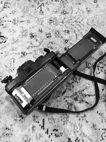 Photograph of the back of a film camera with a roll of film loaded in it