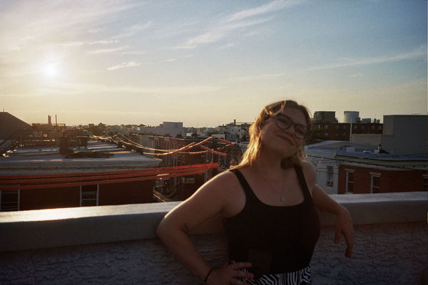 Photograph of someone looking at the camera and smiling on a rooftop