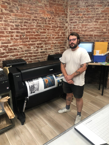 Photograph of printer with photos coming out of it in the print lab at PhotoLounge with Sam