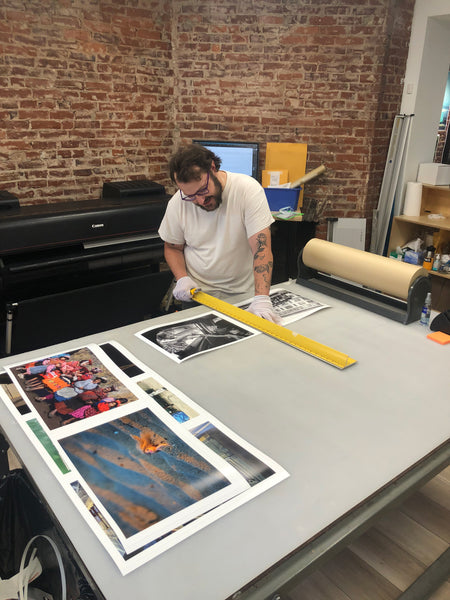 Photograph of Sam cutting down prints in the PhotoLounge print lab