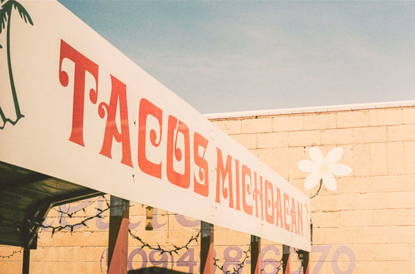 Photograph looking across a taco restaurant's store front sign
