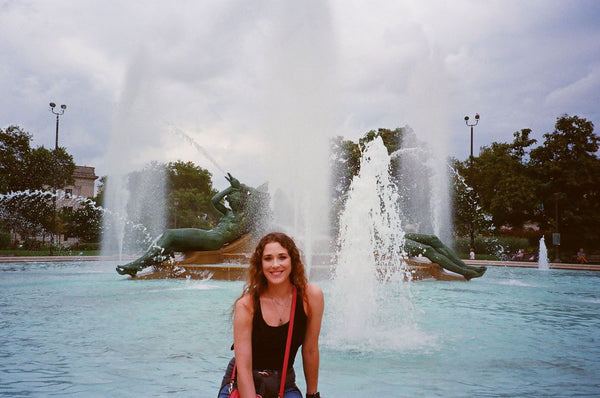Photograph of someone sitting next to the fountain in Logan Square in Philadelphiaadelphia