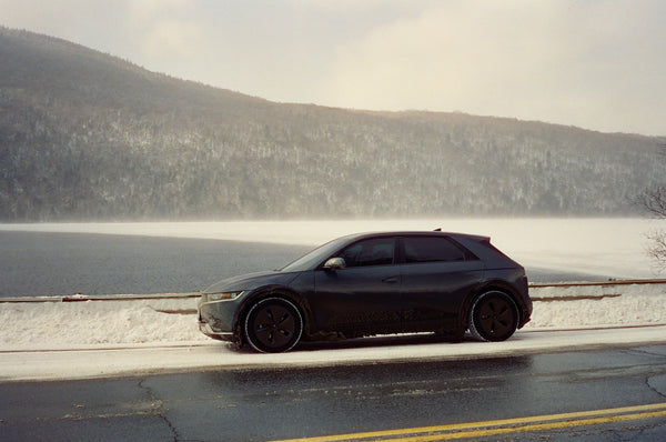 Photograph of a car driving through a snowscape