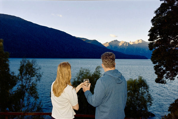 Photograph of two people staring out at lake