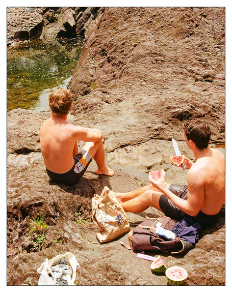 Photograph of people eating on a mountain