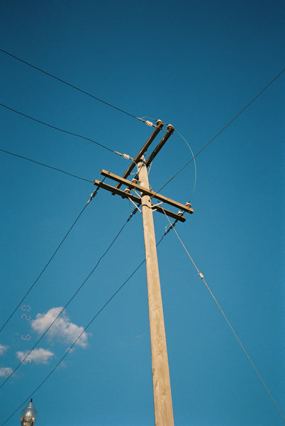 Photograph of telephone pole against blue sky
