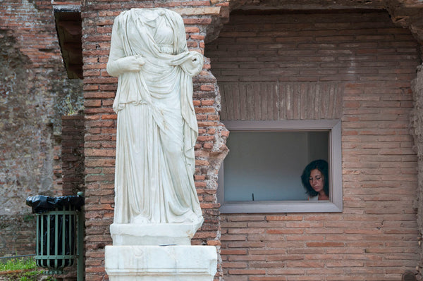 Photograph of Nike statue and person peeking out of window