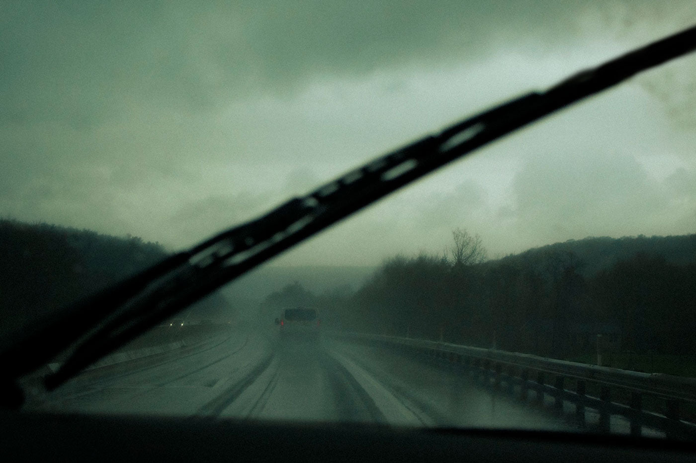 Photograph taken while driving through the windshield of car with wipers on in the rain