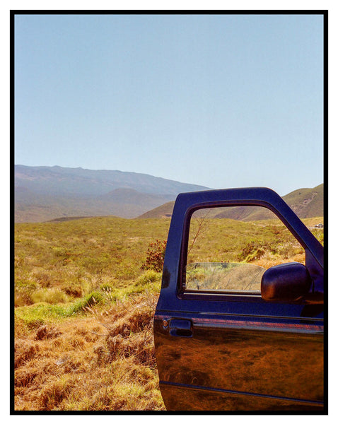 Photograph of a car door open in a landscape in Hawaii
