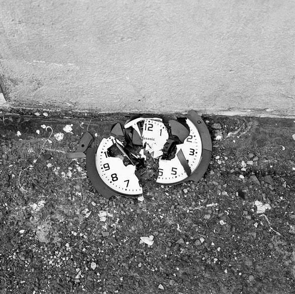Photograph of broken clock on the ground
