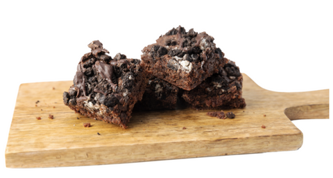 Indulgent oreo brownies stacked on a wooden serving board 