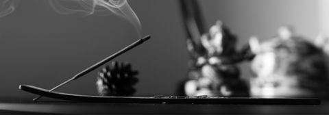 Stick incense burning in a wooden holder