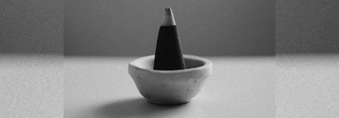 Cone incense in a small stone bowl on a table