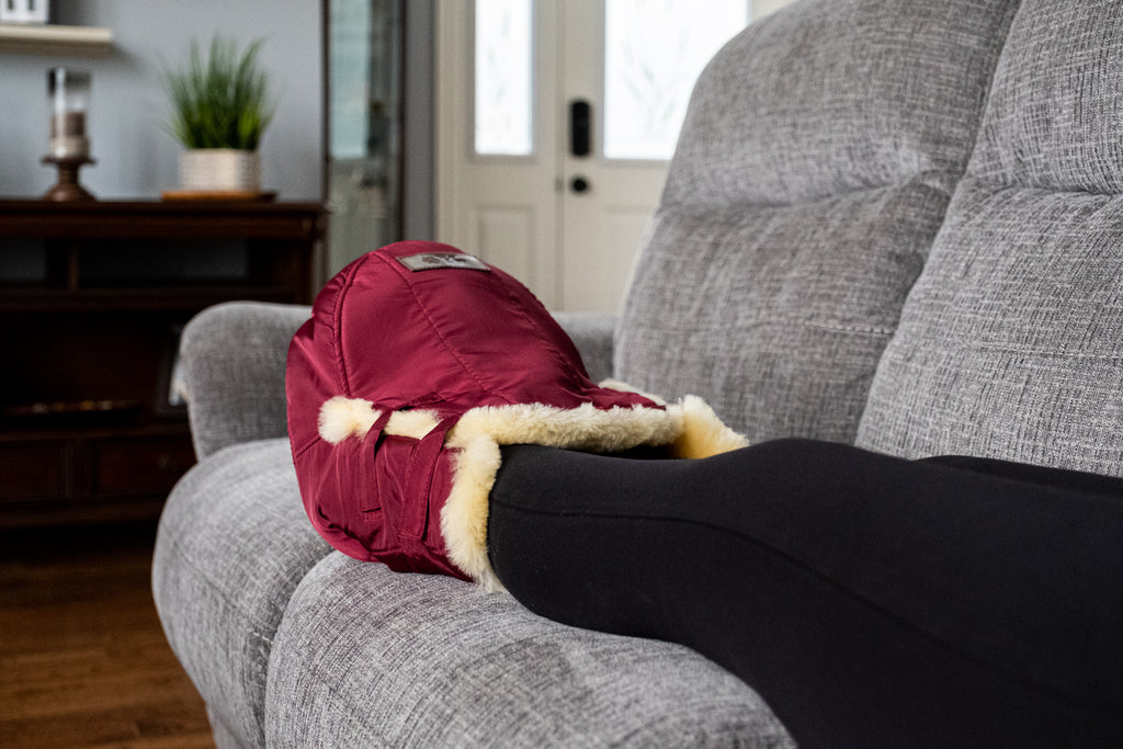 Sitting on the couch with a burgundy snuggly foot warmer sheepskin muff
