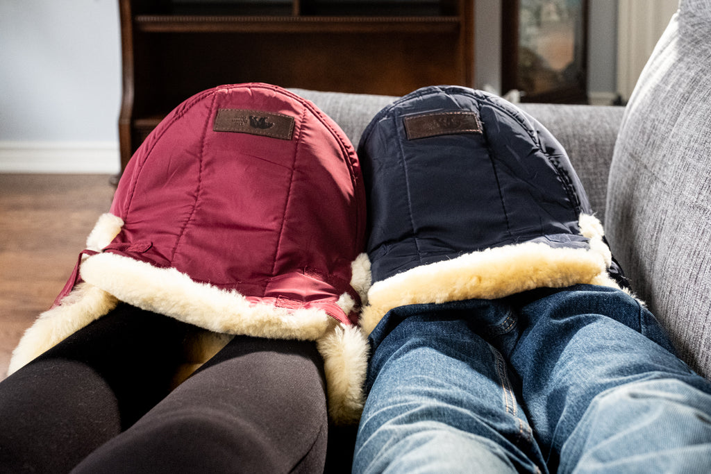 couple snuggling together on couch with cozy sheepskin foot warmers muffs