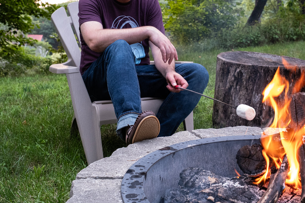 Enjoying roasting marshmallows over an open fire with traditional moccasins
