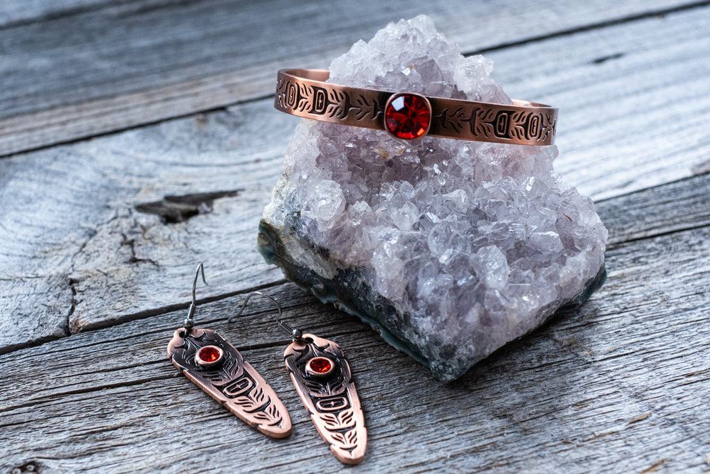 Sacred Feather copper earrings and a matching copper bangle