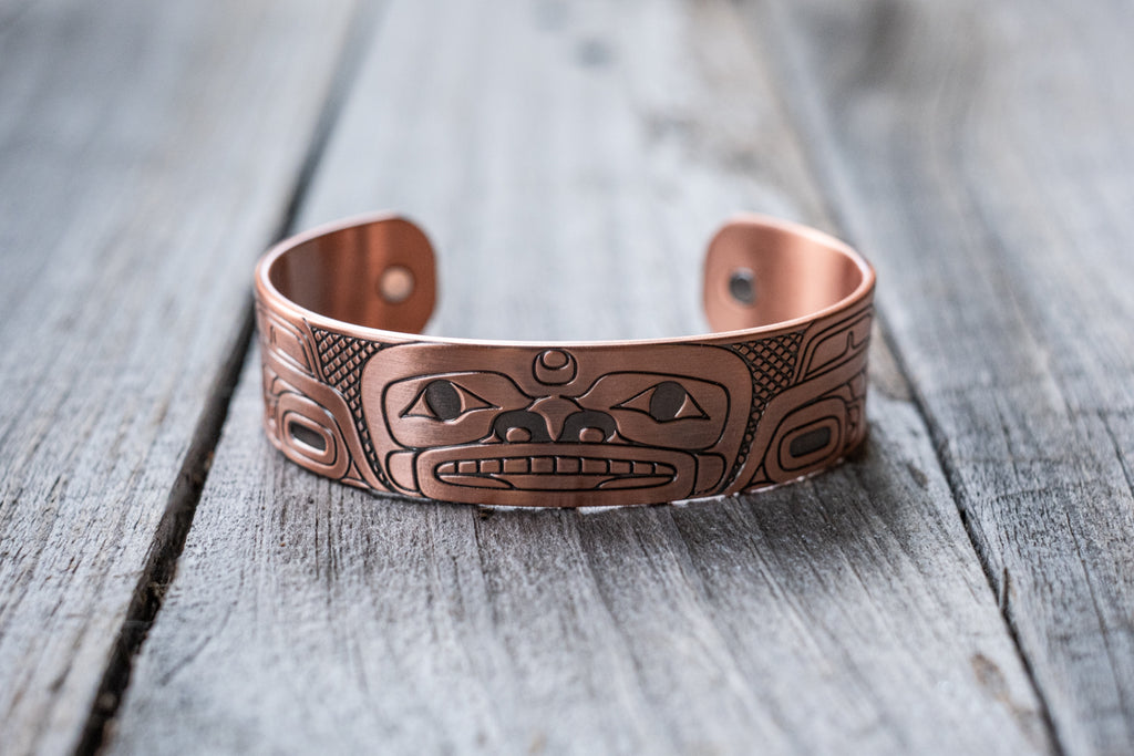 Engraved with striking Indigenous artwork this copper band is crafted in open-cuff style with two healing magnets