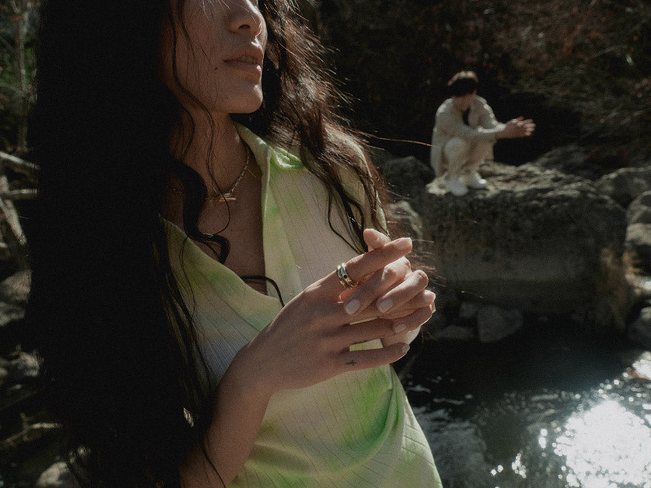 female and male models by the river and rocks