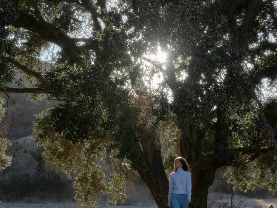 model standing in front of a tree looking away