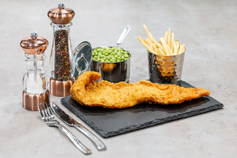 fish and chips on a slate place matt with salt shaker and pepper mill