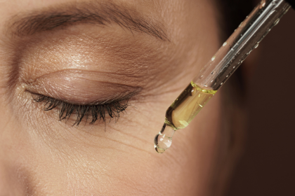 Woman applying a serum on cheek