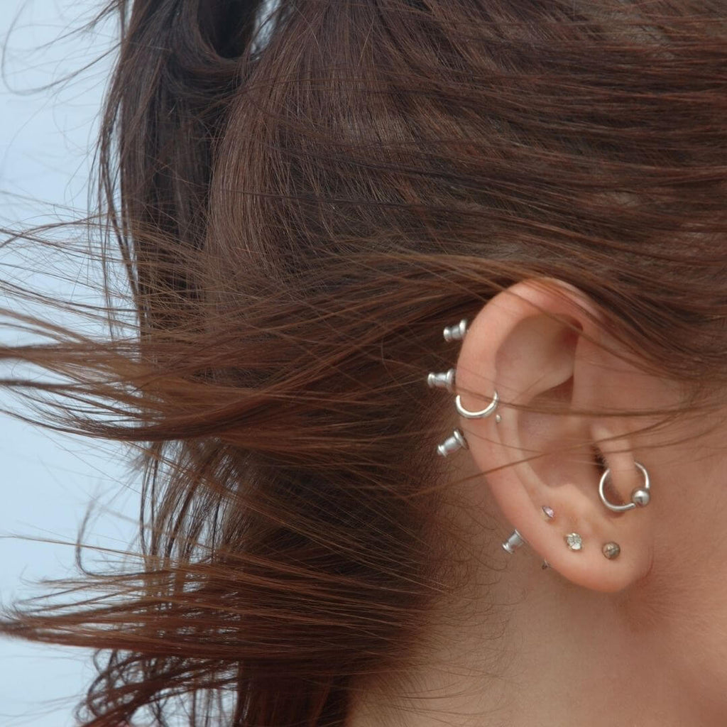 brunette-showing-multiple-cartilage-ear-piercings