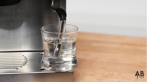 espresso machine steam wand soaked in hot water