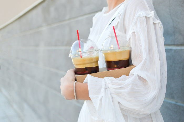 woman holding two cups of cold brew coffee
